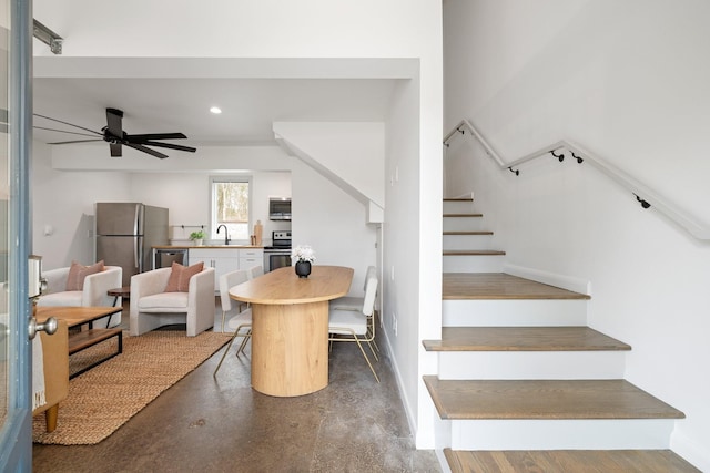 dining space featuring ceiling fan and sink