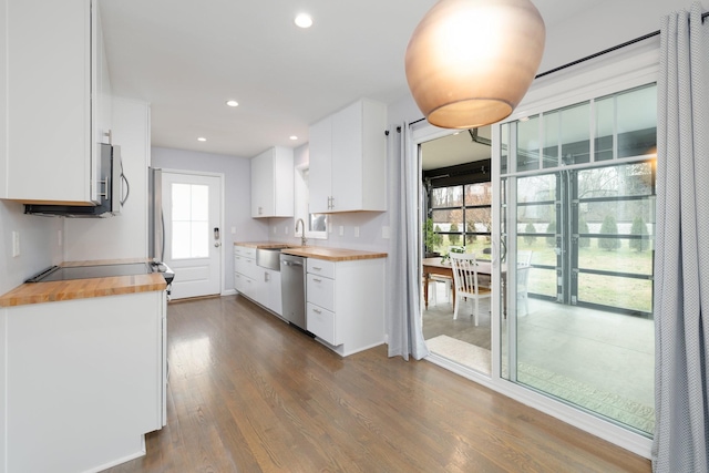 kitchen featuring white cabinetry, dark wood-type flooring, stainless steel dishwasher, and wooden counters