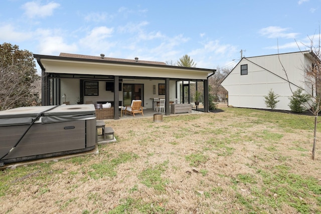 back of house with a hot tub, an outdoor hangout area, and a lawn