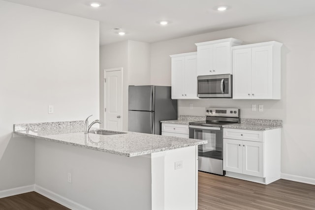 kitchen with white cabinetry, appliances with stainless steel finishes, and kitchen peninsula