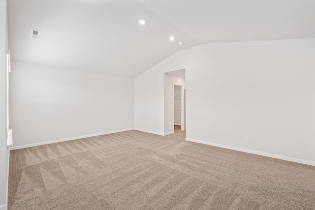 additional living space featuring lofted ceiling and light colored carpet