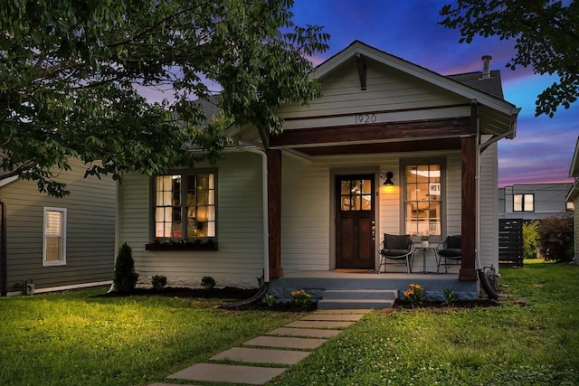 bungalow-style home with a lawn and a porch