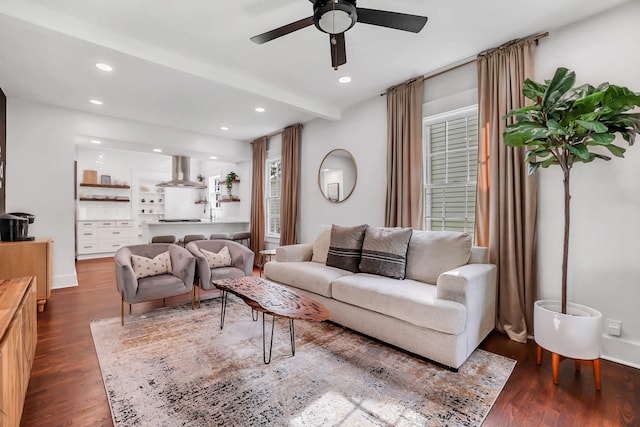 living room featuring hardwood / wood-style flooring, beamed ceiling, and ceiling fan