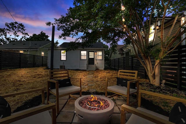 patio terrace at dusk featuring an outdoor fire pit and an outdoor structure