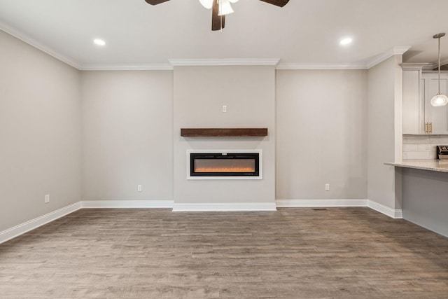 unfurnished living room featuring crown molding, wood-type flooring, and ceiling fan