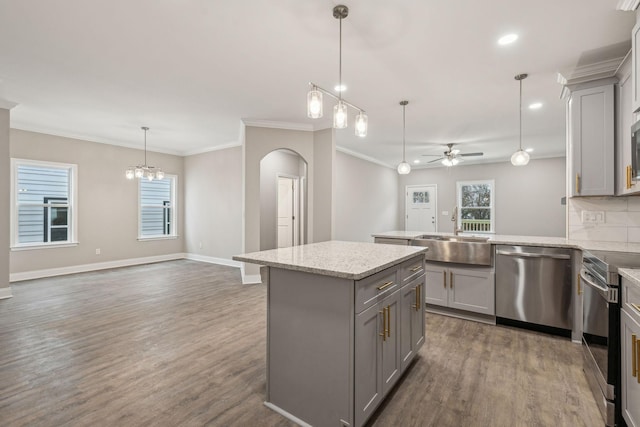 kitchen featuring sink, appliances with stainless steel finishes, gray cabinetry, a center island, and decorative light fixtures