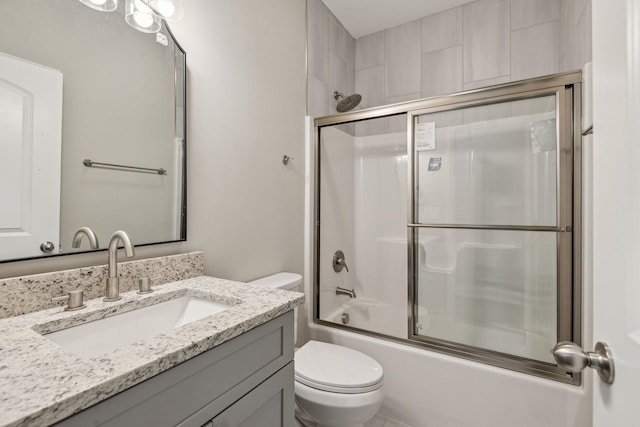 full bathroom featuring toilet, vanity, and shower / bath combination with glass door