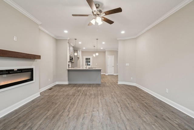 unfurnished living room with crown molding, dark hardwood / wood-style floors, and ceiling fan