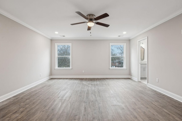 empty room featuring hardwood / wood-style flooring, ornamental molding, a healthy amount of sunlight, and ceiling fan