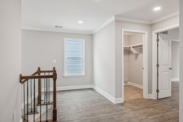 hallway with hardwood / wood-style flooring and ornamental molding