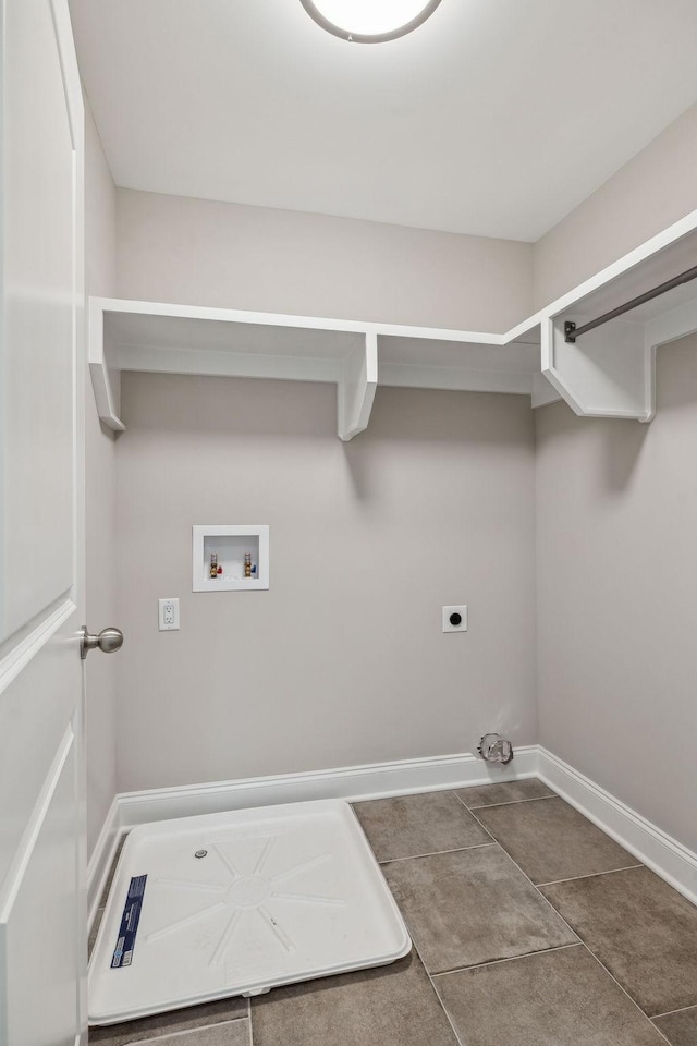 washroom with electric dryer hookup, dark tile patterned flooring, and hookup for a washing machine