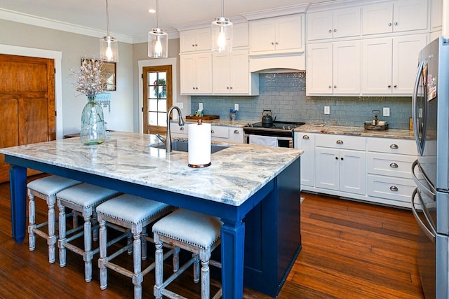 kitchen with a kitchen island with sink, pendant lighting, and stainless steel appliances