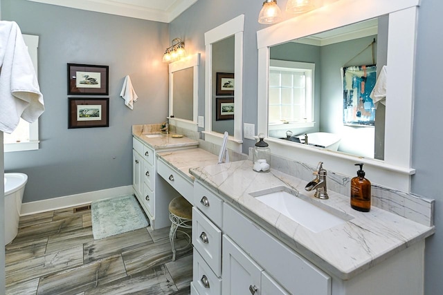 bathroom featuring a tub to relax in, ornamental molding, vanity, and plenty of natural light