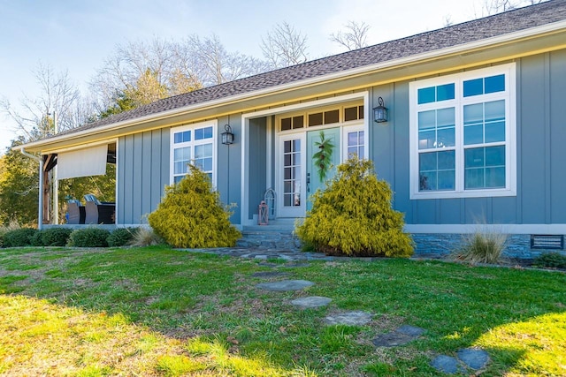 entrance to property featuring a lawn