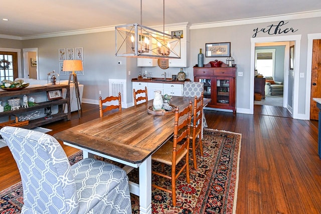 dining space featuring a healthy amount of sunlight, ornamental molding, dark hardwood / wood-style floors, and sink