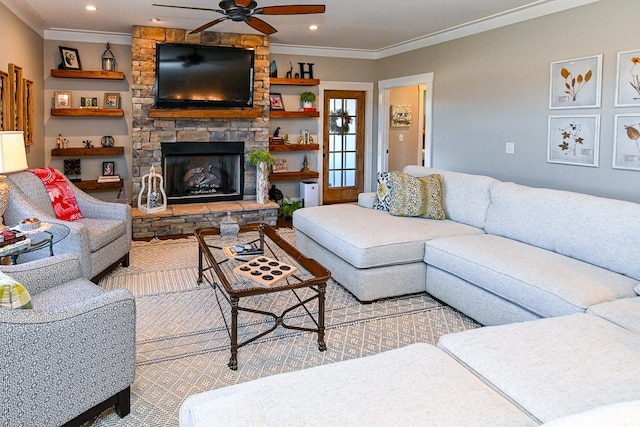 living room with crown molding, a stone fireplace, and ceiling fan