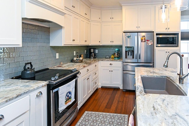 kitchen featuring appliances with stainless steel finishes, pendant lighting, sink, custom exhaust hood, and light stone countertops