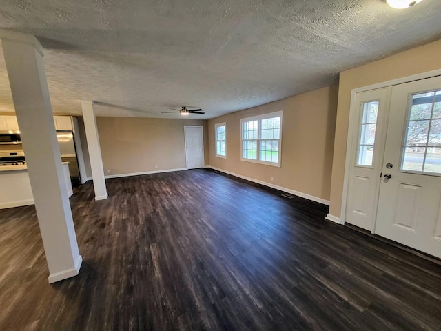 unfurnished living room featuring ceiling fan, a textured ceiling, and dark hardwood / wood-style flooring