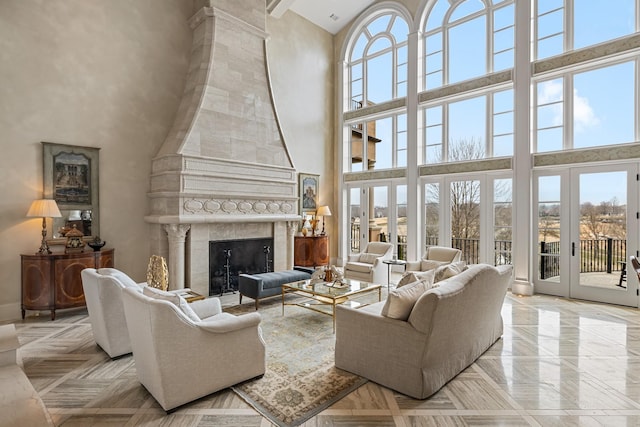 living room with a premium fireplace, light parquet flooring, and a high ceiling