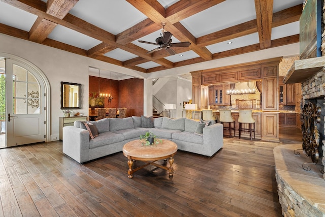 living room featuring coffered ceiling, a fireplace, dark wood-type flooring, and beamed ceiling