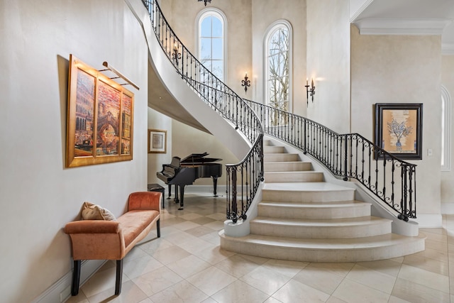 stairs with a towering ceiling and ornamental molding