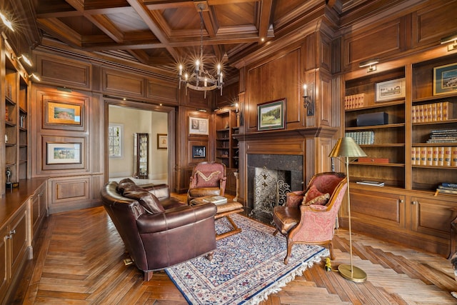 living area featuring coffered ceiling, wood walls, crown molding, built in features, and a fireplace