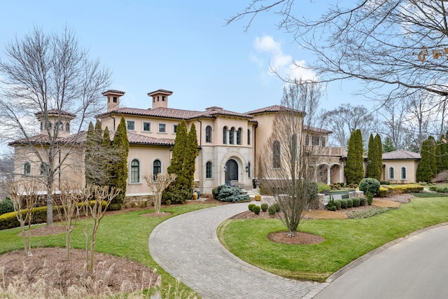 mediterranean / spanish-style house featuring a front lawn