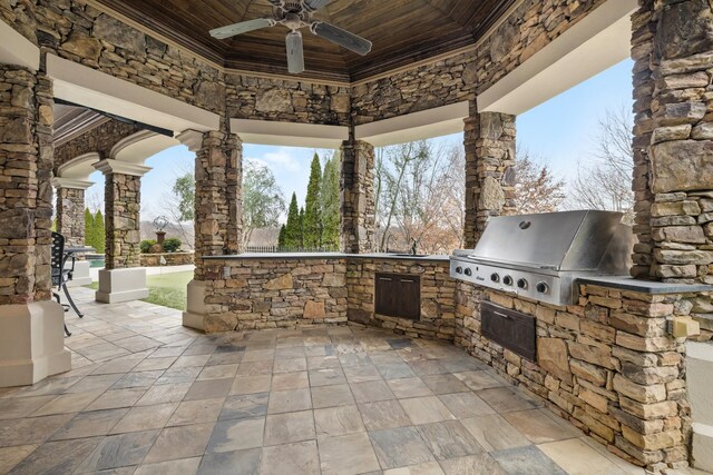 view of patio with ceiling fan, an outdoor kitchen, and a grill