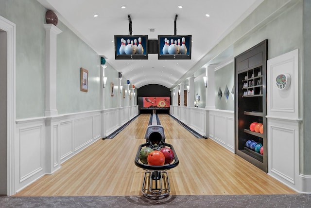 game room with built in shelves, bowling, decorative columns, and vaulted ceiling