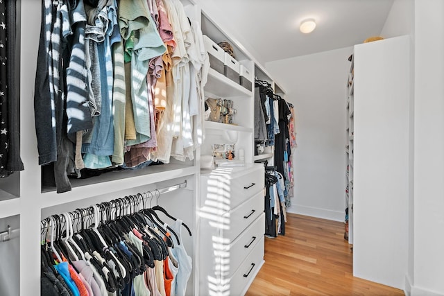 walk in closet with light hardwood / wood-style flooring