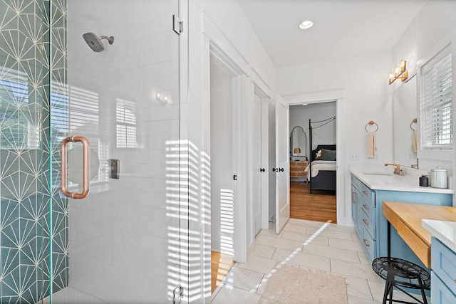 bathroom featuring tile patterned floors, a shower with door, and vanity