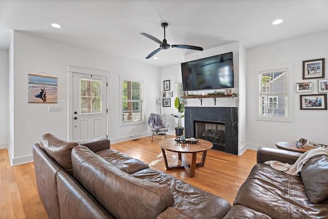 living room with ceiling fan, plenty of natural light, and light hardwood / wood-style floors