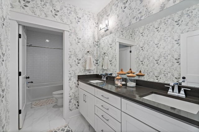 full bathroom featuring vanity, tiled shower / bath combo, and toilet