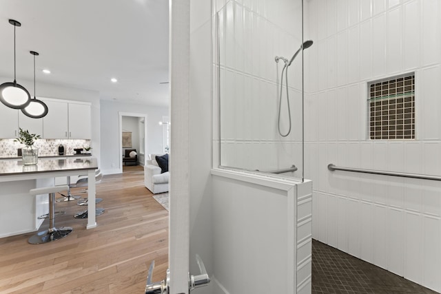 bathroom featuring tasteful backsplash, hardwood / wood-style floors, and walk in shower