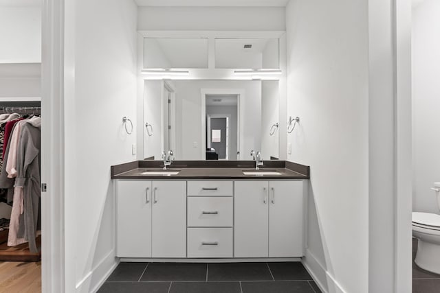 bathroom with vanity, toilet, and tile patterned flooring