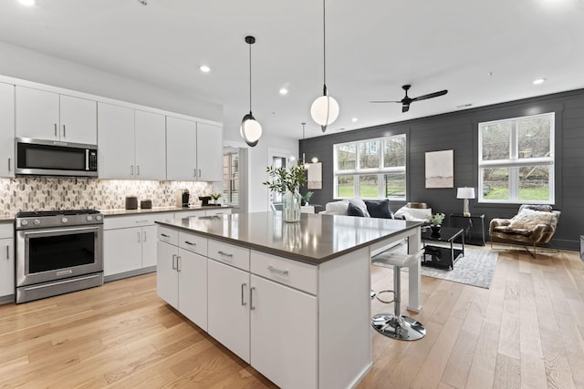 kitchen with white cabinetry, pendant lighting, stainless steel appliances, and a center island