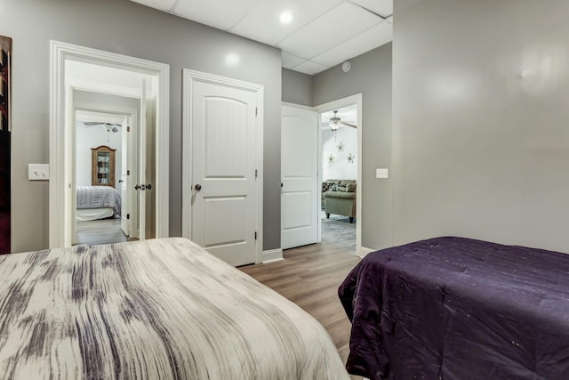 bedroom with light hardwood / wood-style flooring and a paneled ceiling