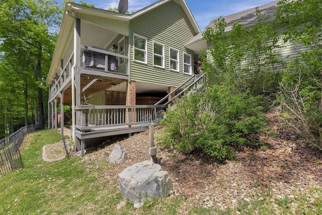 rear view of house with a balcony and a yard