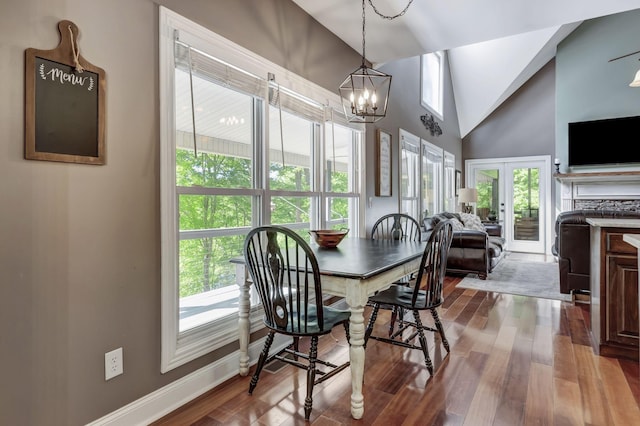 dining area featuring hardwood / wood-style flooring, high vaulted ceiling, french doors, and a healthy amount of sunlight