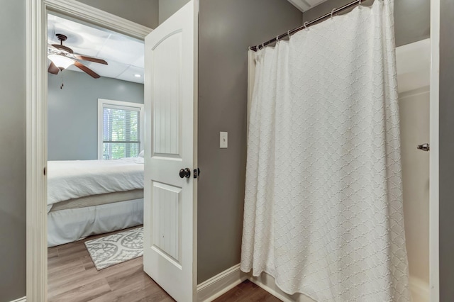 bathroom with ceiling fan, shower / tub combo with curtain, and hardwood / wood-style floors