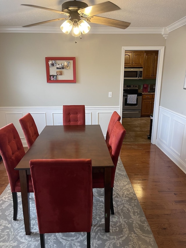 dining space with ceiling fan, ornamental molding, dark hardwood / wood-style flooring, and a textured ceiling