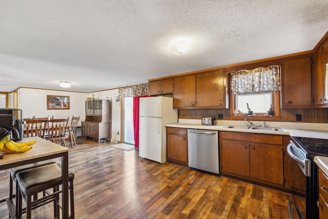 kitchen with stainless steel appliances, sink, dark wood-type flooring, and a textured ceiling