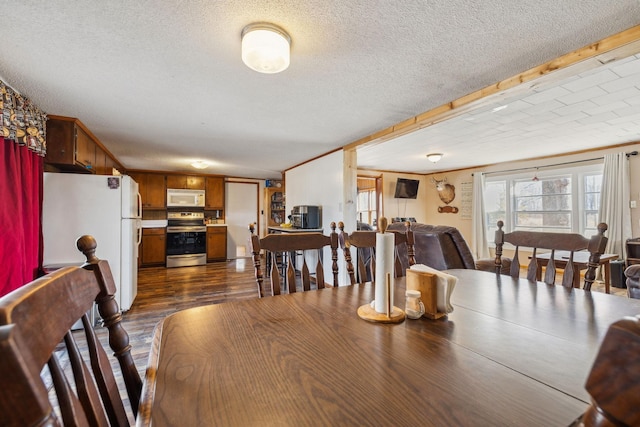 dining room featuring crown molding, dark hardwood / wood-style floors, and a textured ceiling