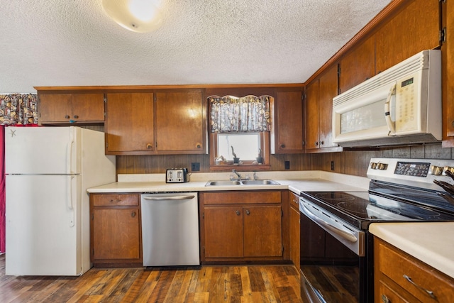 kitchen featuring sink, dark wood-type flooring, stainless steel appliances, and a textured ceiling