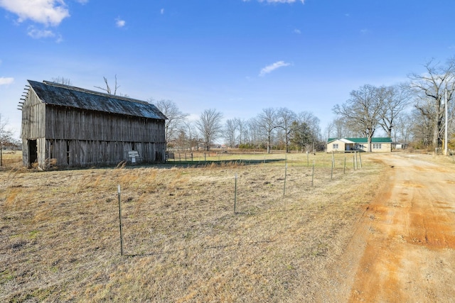 view of yard with an outbuilding and a rural view