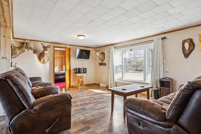 living room featuring crown molding and hardwood / wood-style flooring