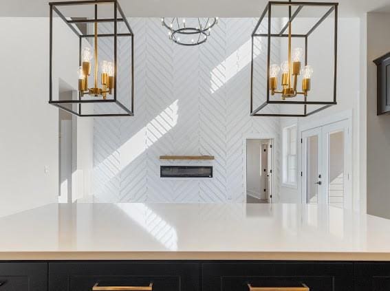 interior space featuring french doors, a notable chandelier, light countertops, hanging light fixtures, and dark cabinetry