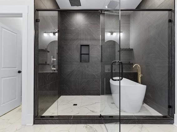 bathroom with marble finish floor, a shower stall, visible vents, and a freestanding tub