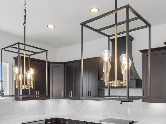 interior space with tasteful backsplash, recessed lighting, light countertops, and black electric stovetop