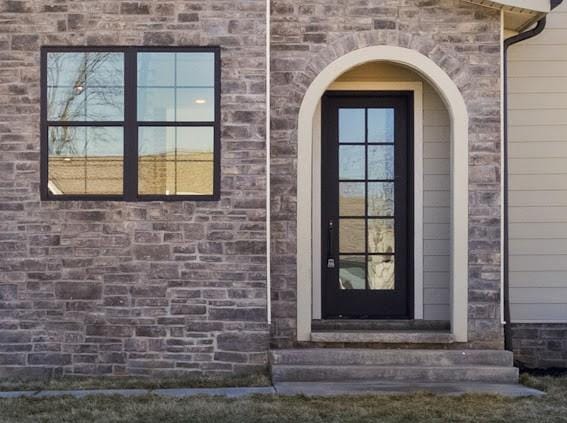 view of exterior entry featuring brick siding